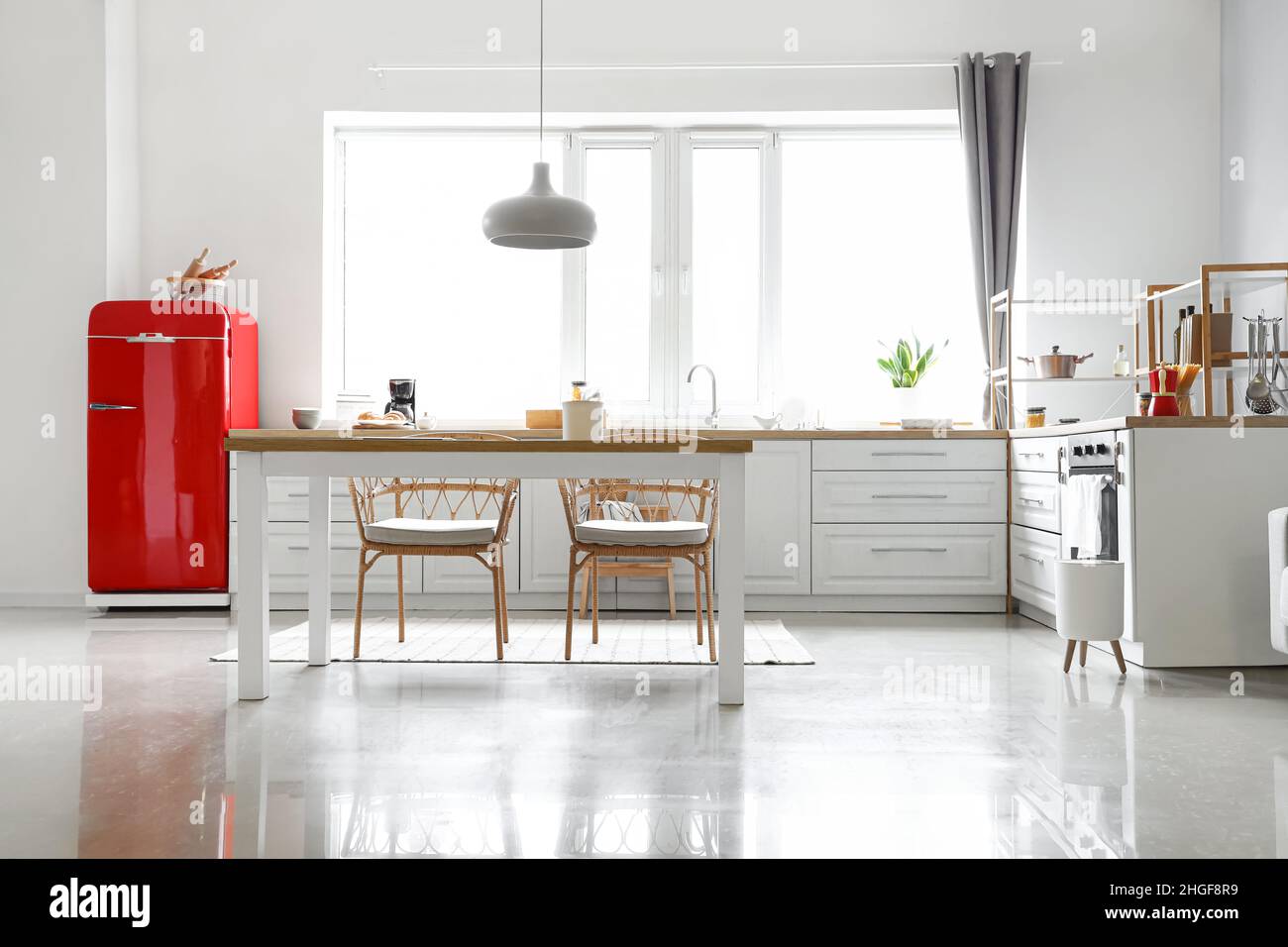 Interior of light modern kitchen with red fridge, white counters and ...