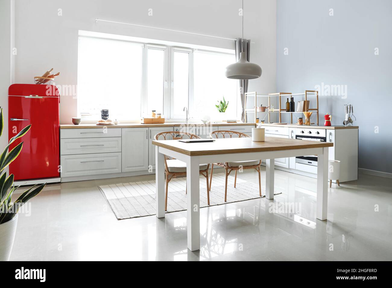 Interior of light modern kitchen with red fridge, white counters and ...