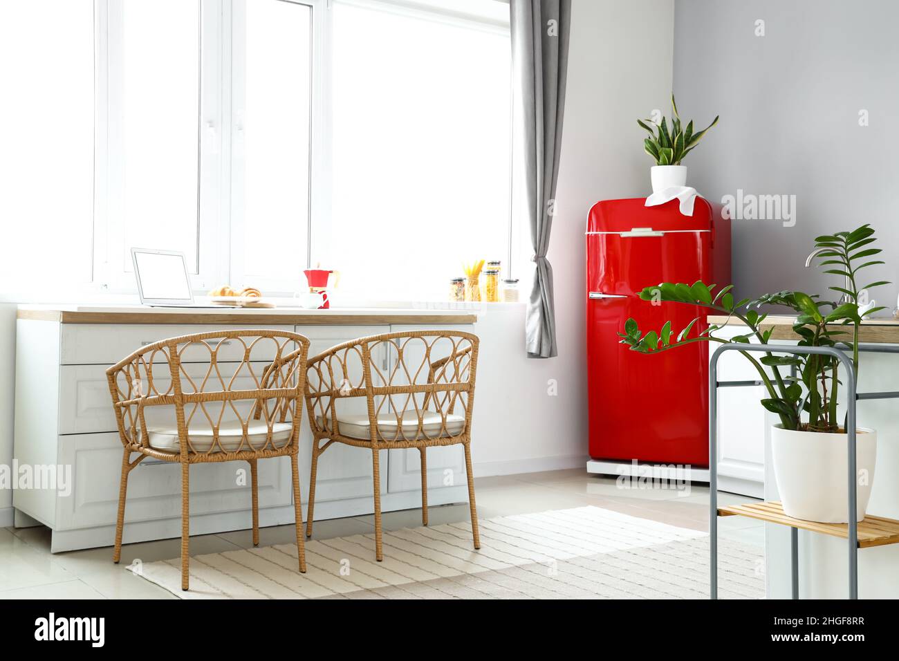 Interior of light modern kitchen with red fridge, white counters and ...