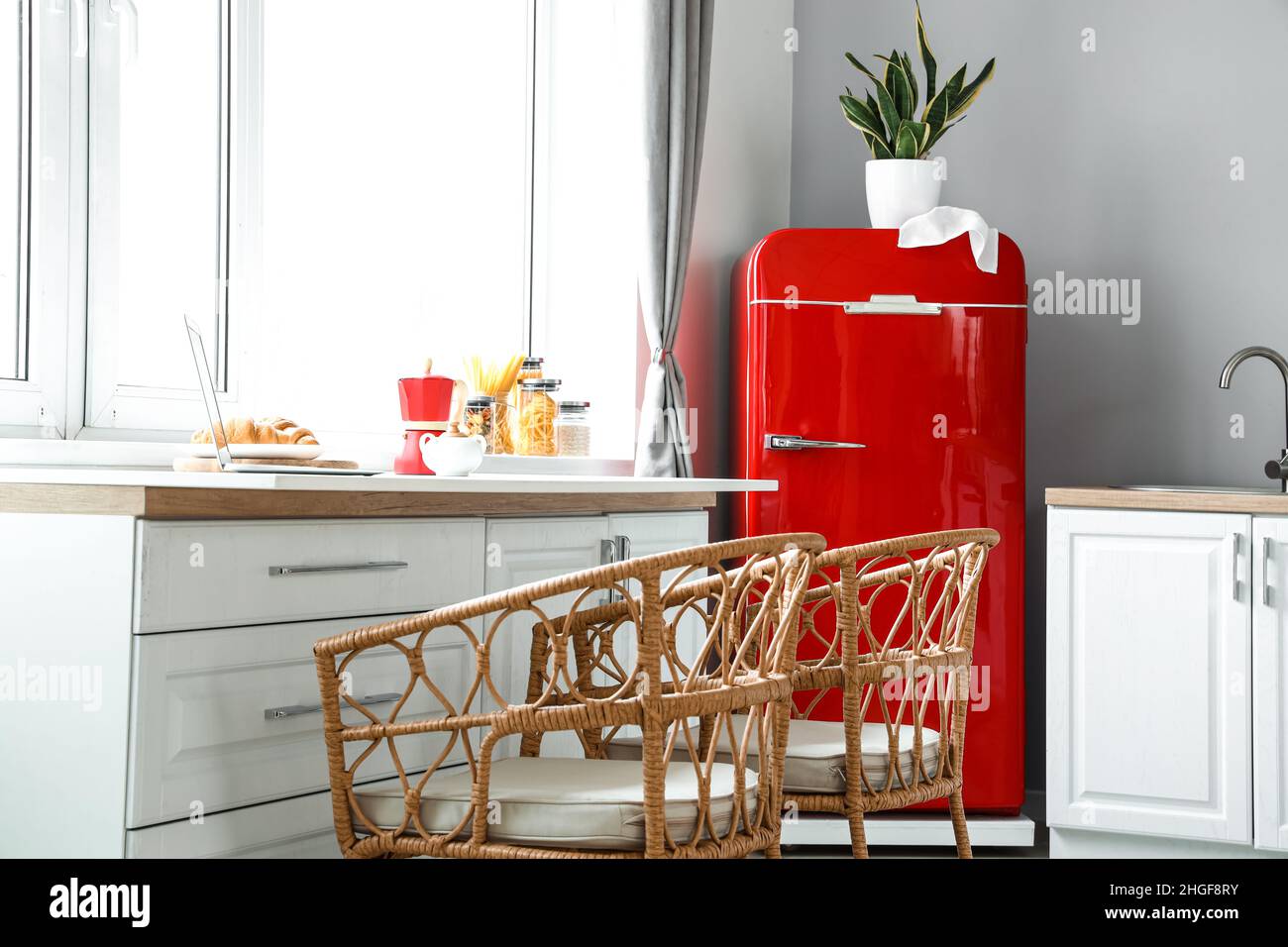 Interior of light modern kitchen with red fridge, white counters and ...
