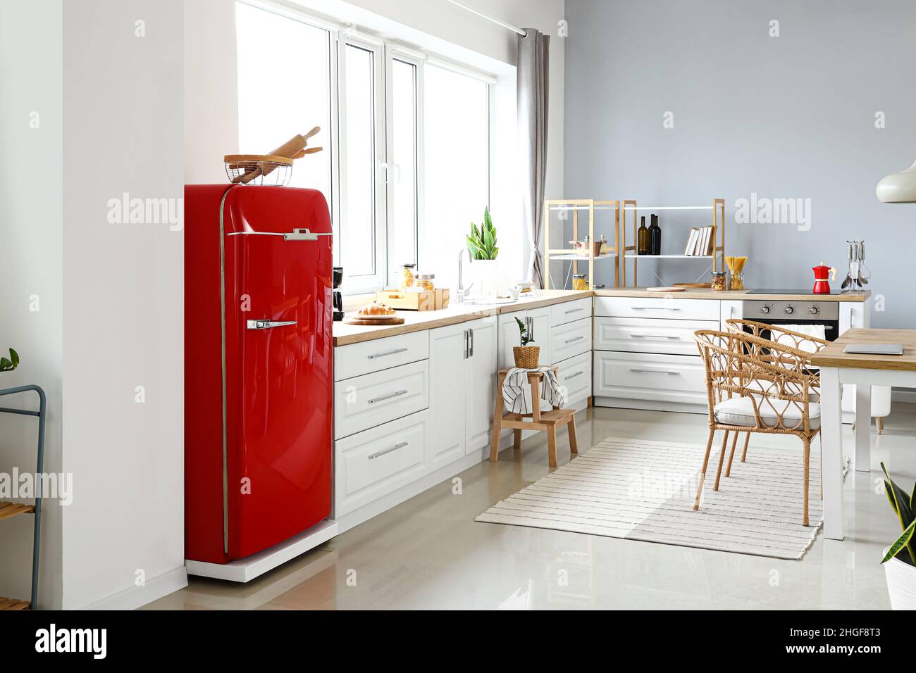 Interior of light modern kitchen with red fridge, white counters and ...
