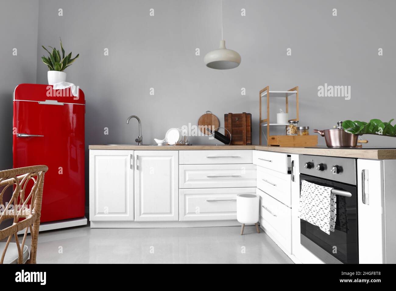 Interior of light modern kitchen with red fridge and white counters ...