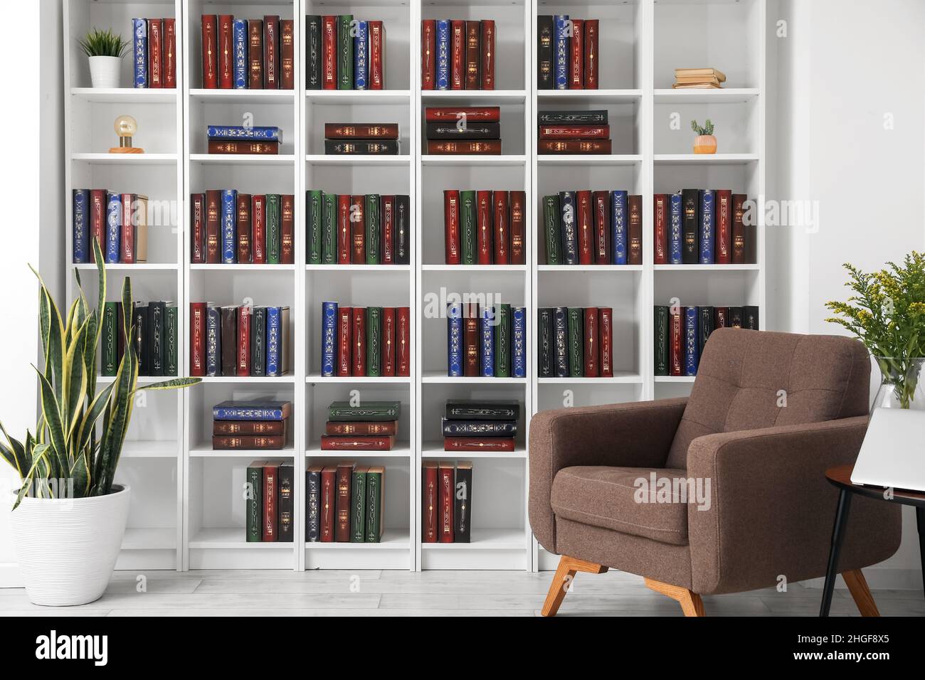 Bookcase with armchair in modern interior of room Stock Photo - Alamy