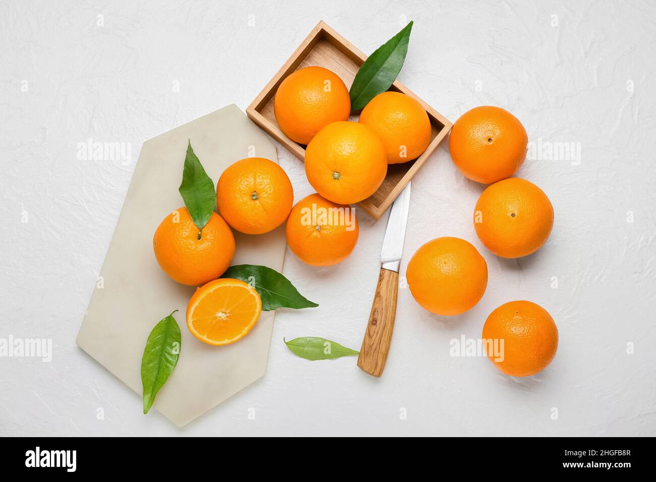 Wooden box and board with fresh juicy oranges on white background Stock ...