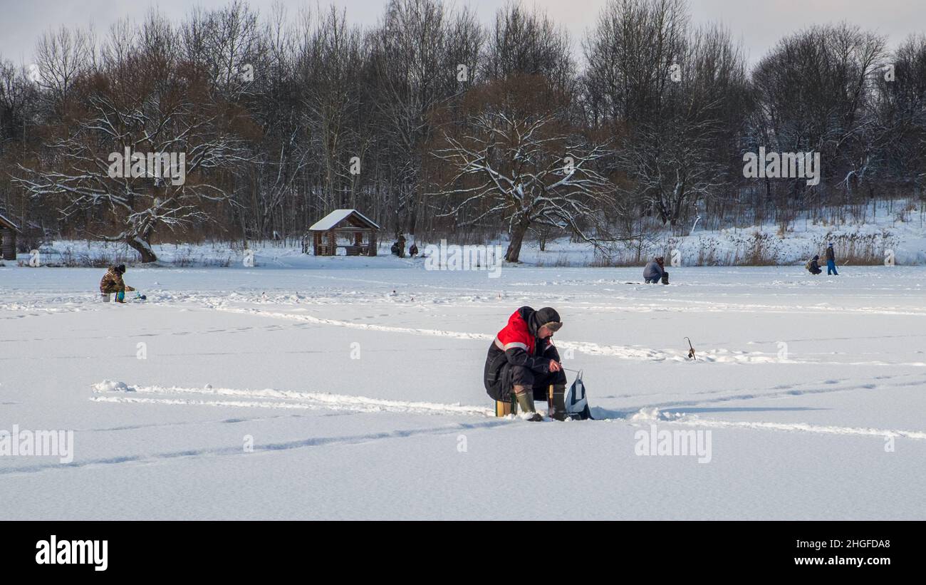 Ice fishing. Anglers catching fish in early spring on the last ice. Drozdy reservoir. Belarus. Minsk. Stock Photo