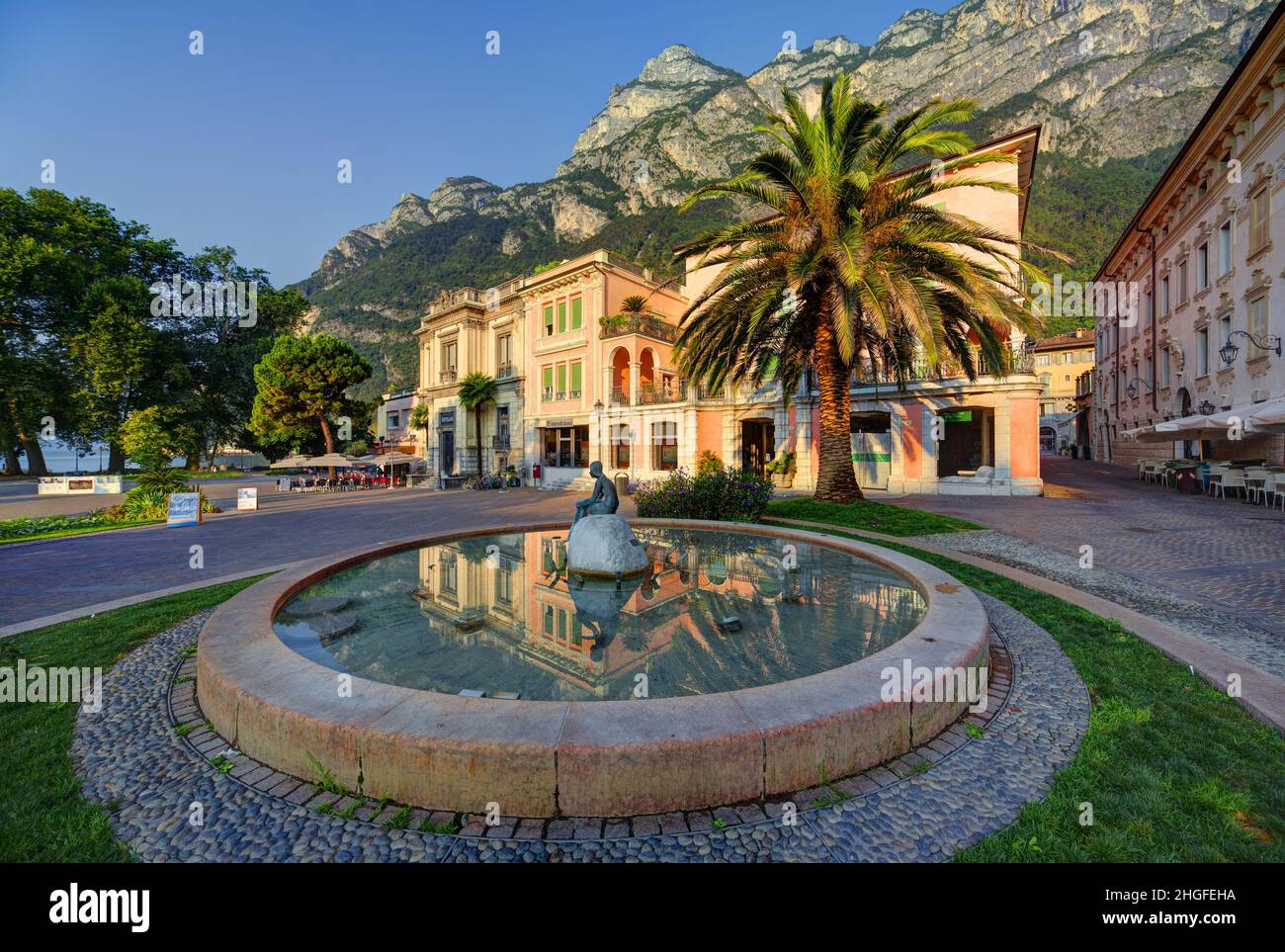 Riva del Garda, Italy, Trento, palm tree and italian villa with Garda Lake and mountainas Stock Photo