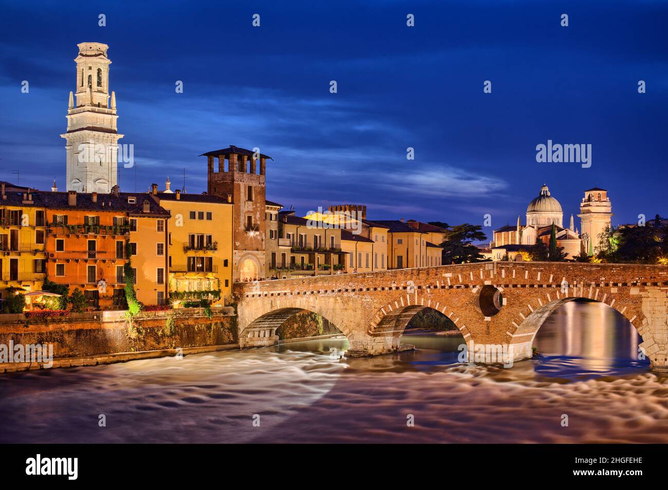 Verona Ponte Pietra Bridge at evening dusk, Verona the Adige river old town at night, Veneto region, Italy Stock Photo