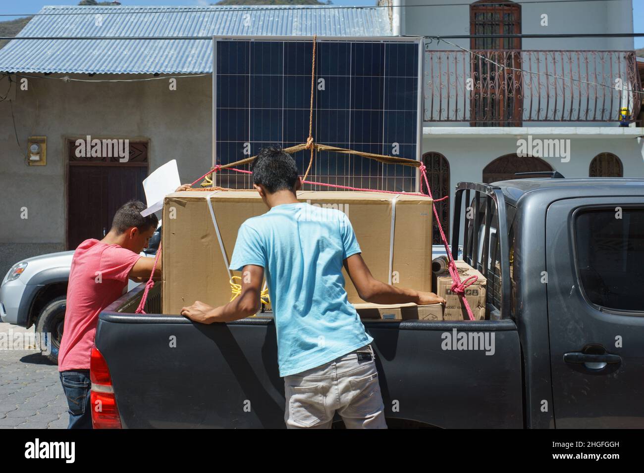 Men load solar panels on a pickup truck in Jinotega, Nicaragua Stock