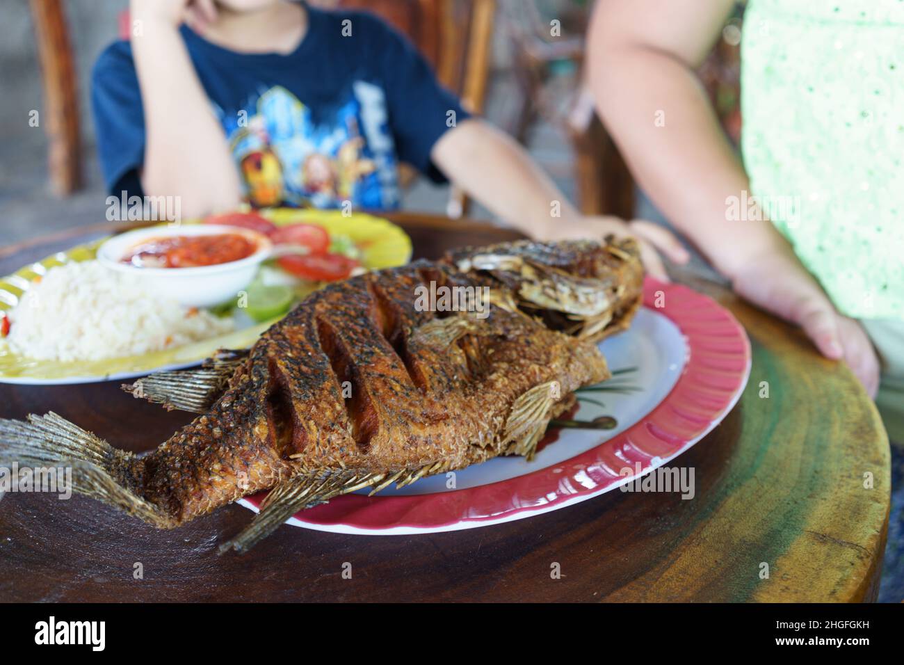 A guapote served  with rice and a salad in a restaurant near Jinotega, Nicaragua.  This Parachromis dovii was caught in Lago Apanas nearby. Stock Photo
