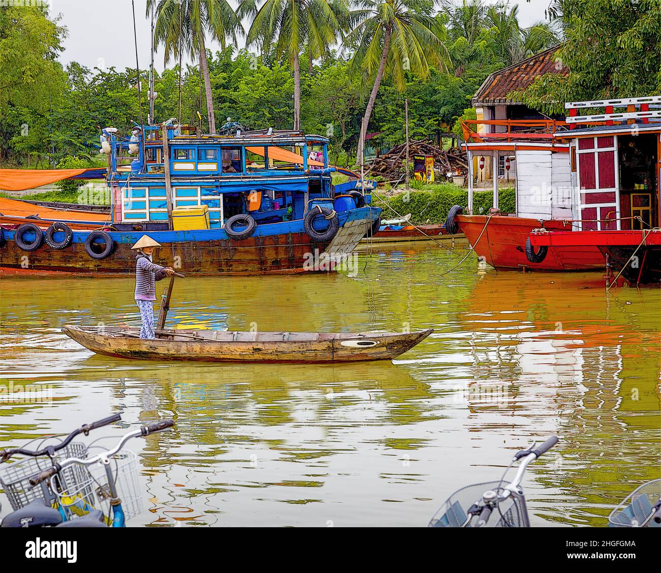 One Vietnamese lady rows her wood boat down the Thu Bon river in Old Town, Hoi An, VN. Stock Photo