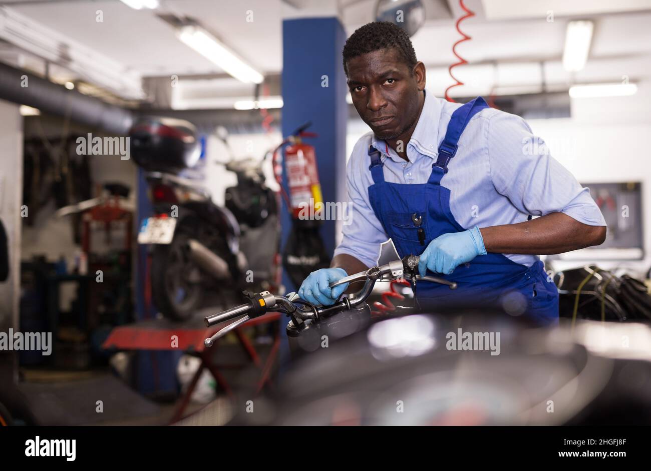 Service engineer repairs a motorcycle steering wheel in a motorcycle service Stock Photo