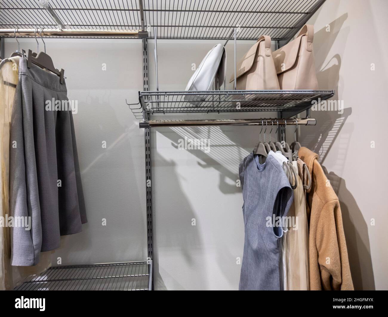 https://c8.alamy.com/comp/2HGFMYX/view-of-a-large-walk-in-closet-with-metal-organizing-racks-storing-dresses-skirts-jackets-and-purses-inside-of-it-2HGFMYX.jpg
