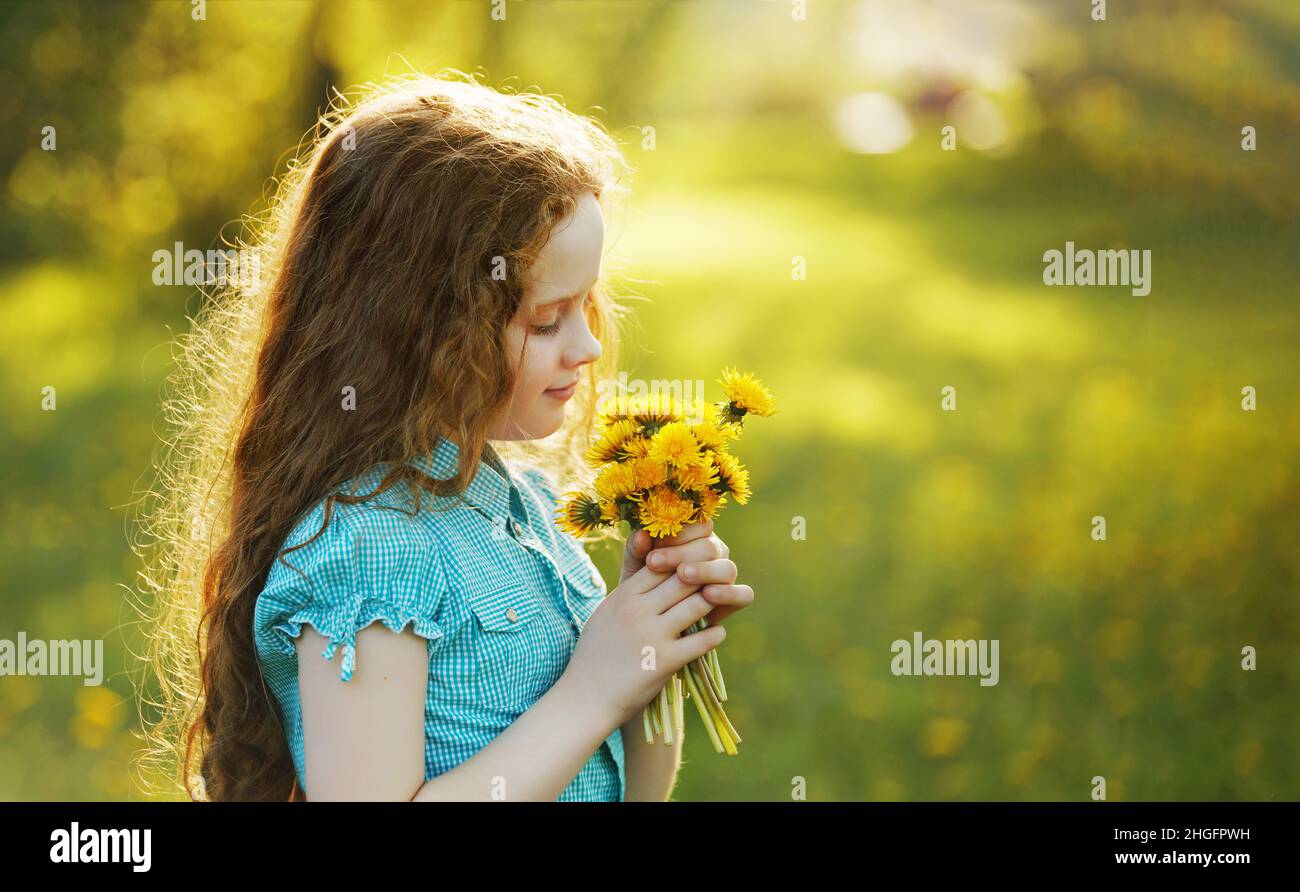 Cute little girl with yellow dandelions in the field Stock Photo - Alamy