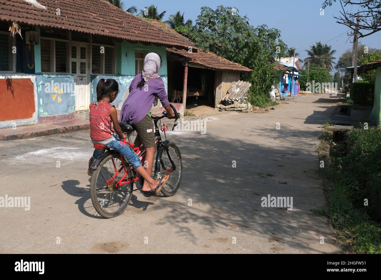 Karnataka, INDIA December 22, 2021, An unidentified Indian rural girls with her bicycle. play time, rural road Stock Photo