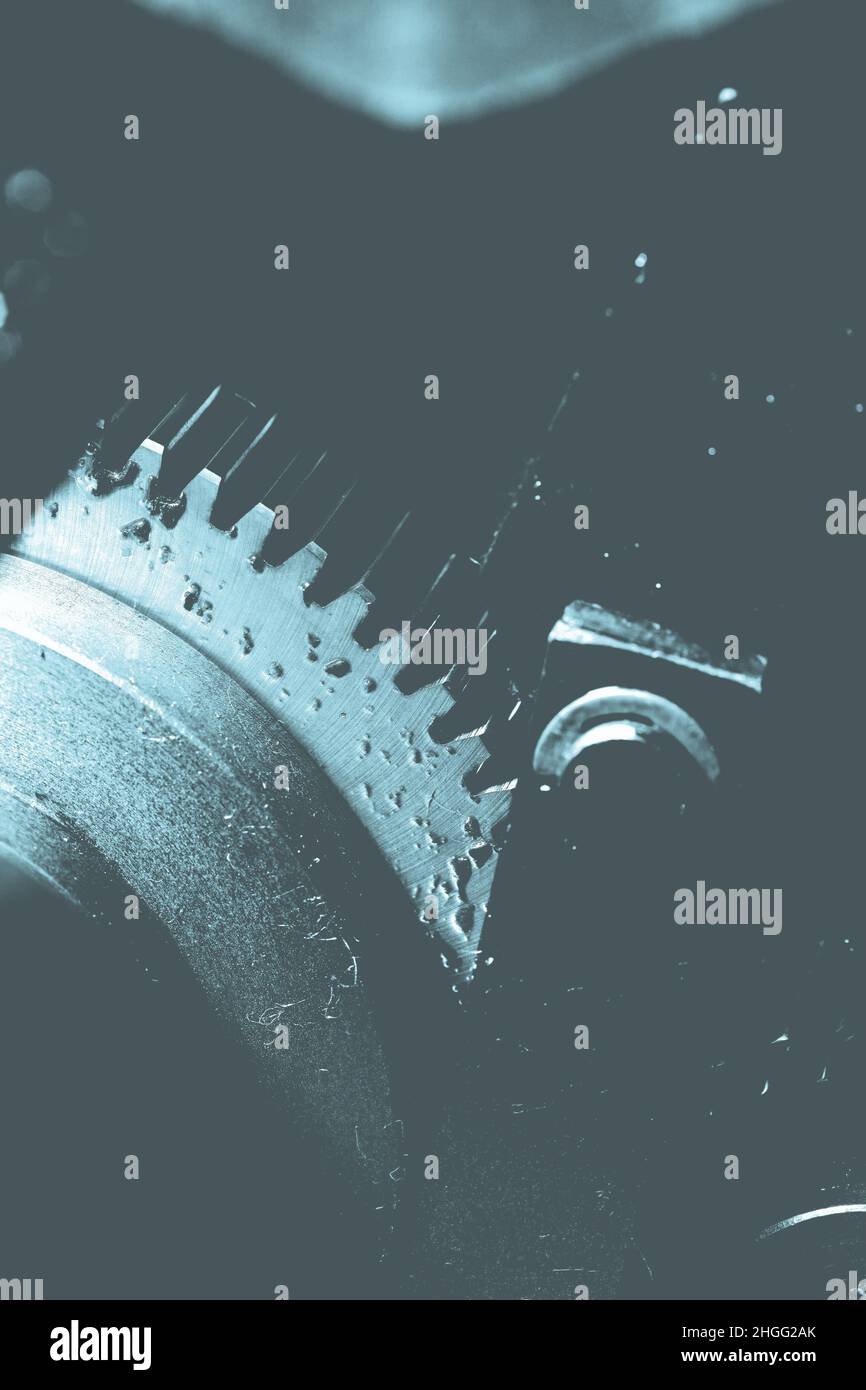 Spinning oily gearwheel as a part of an old big mechanism. Stock Photo