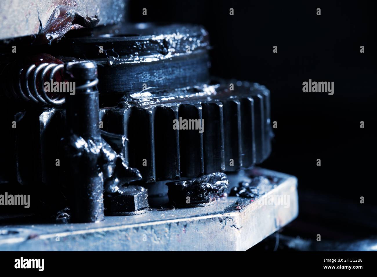 Dirty lubricated gearwheel close-up as an industrial background. Stock Photo