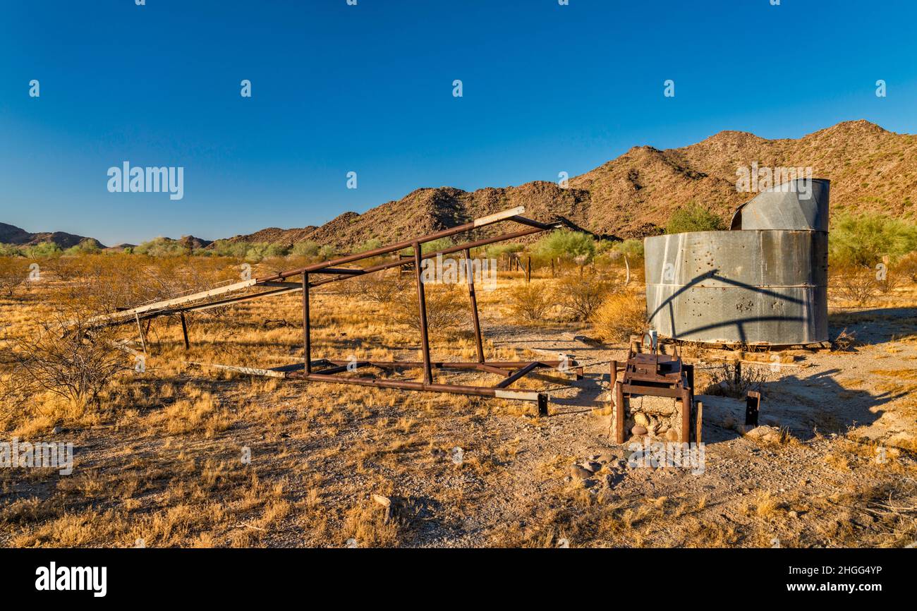 Collapsed wind pump mast, water tank at Hazen Well, former ranch in Margies Cove area, Maricopa Mountains, Sonoran Desert National Monument, Arizona Stock Photo