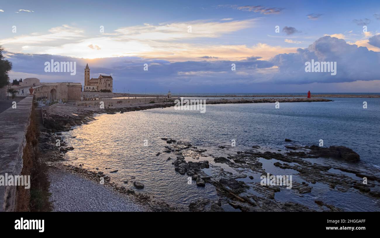 Townscape at sunset of Trani in Puglia, Italy. In the background the Cathedral dedicated to Saint Nicholas the Pilgrim  over the port. Stock Photo