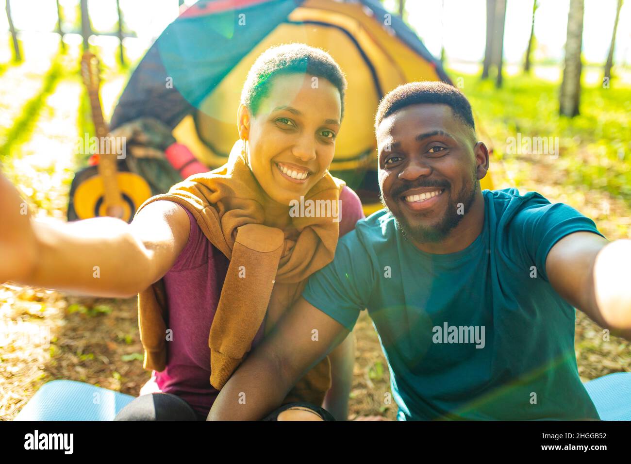 afro latin couple in tent taking selfie using modern smartphone Stock Photo