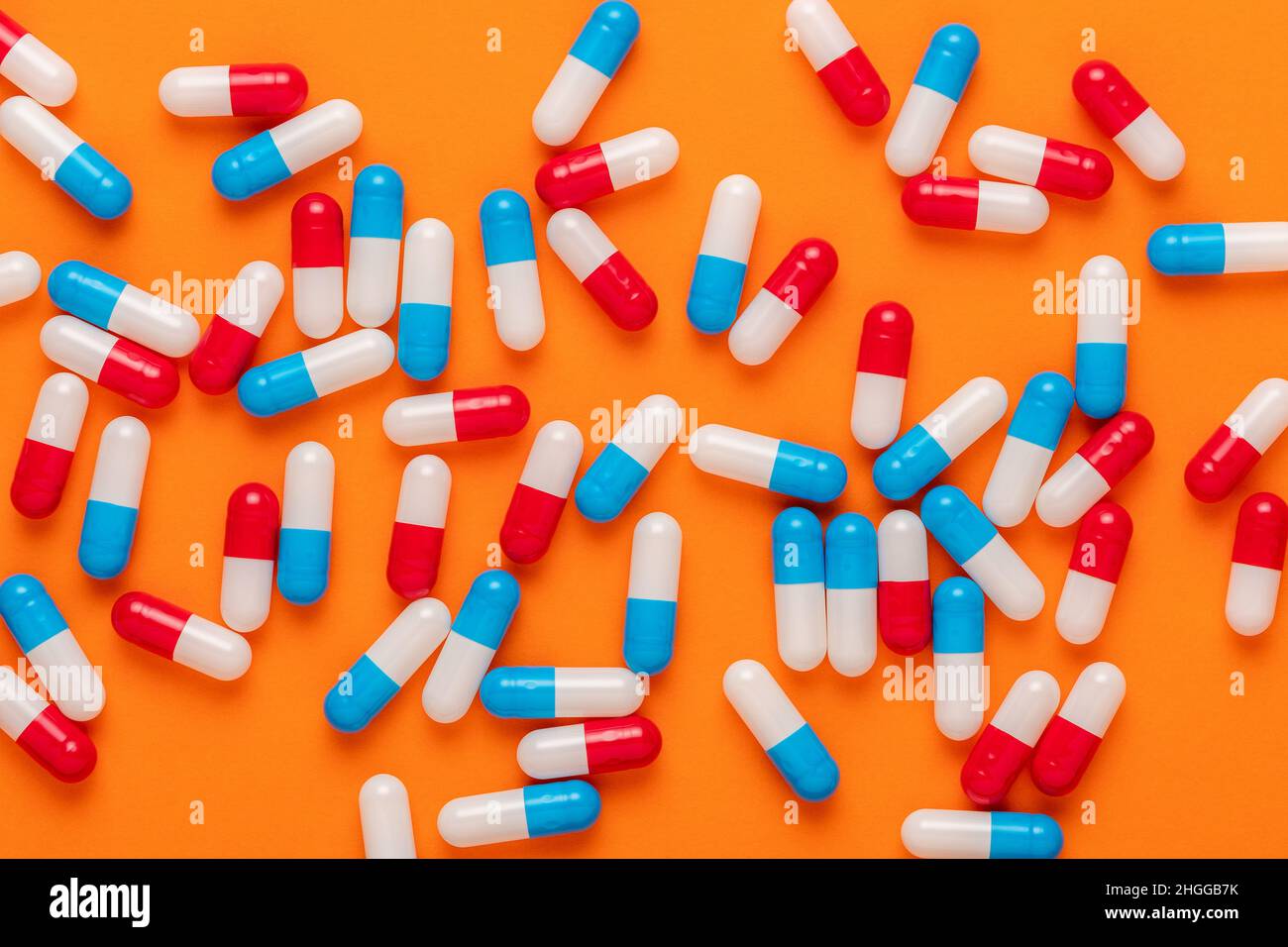 Creative composition with colorful pills on orange background. Minimal concept. Stock Photo