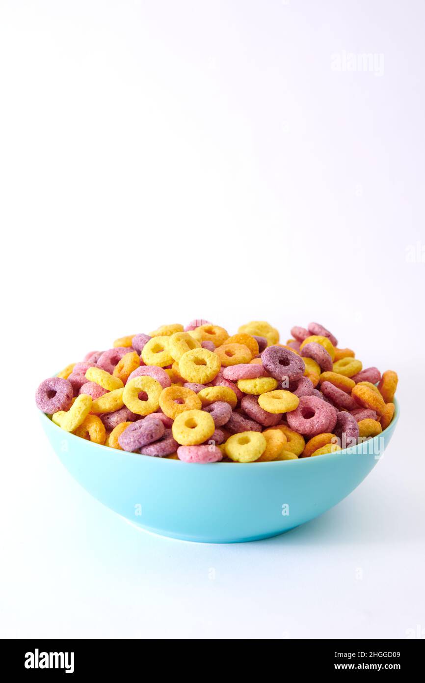 A spoon with multicolored fruity cereals and milk on a blurred background Stock Photo