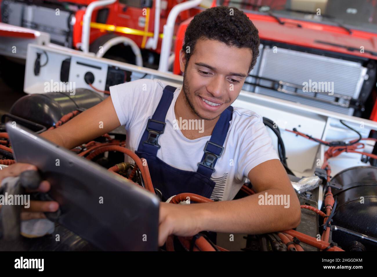 mechanic with digital tablet while examining vehicule Stock Photo