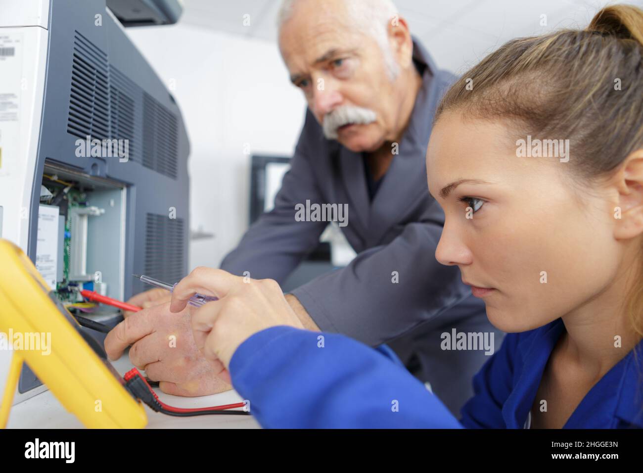 young female technician using multimeter on appliance Stock Photo