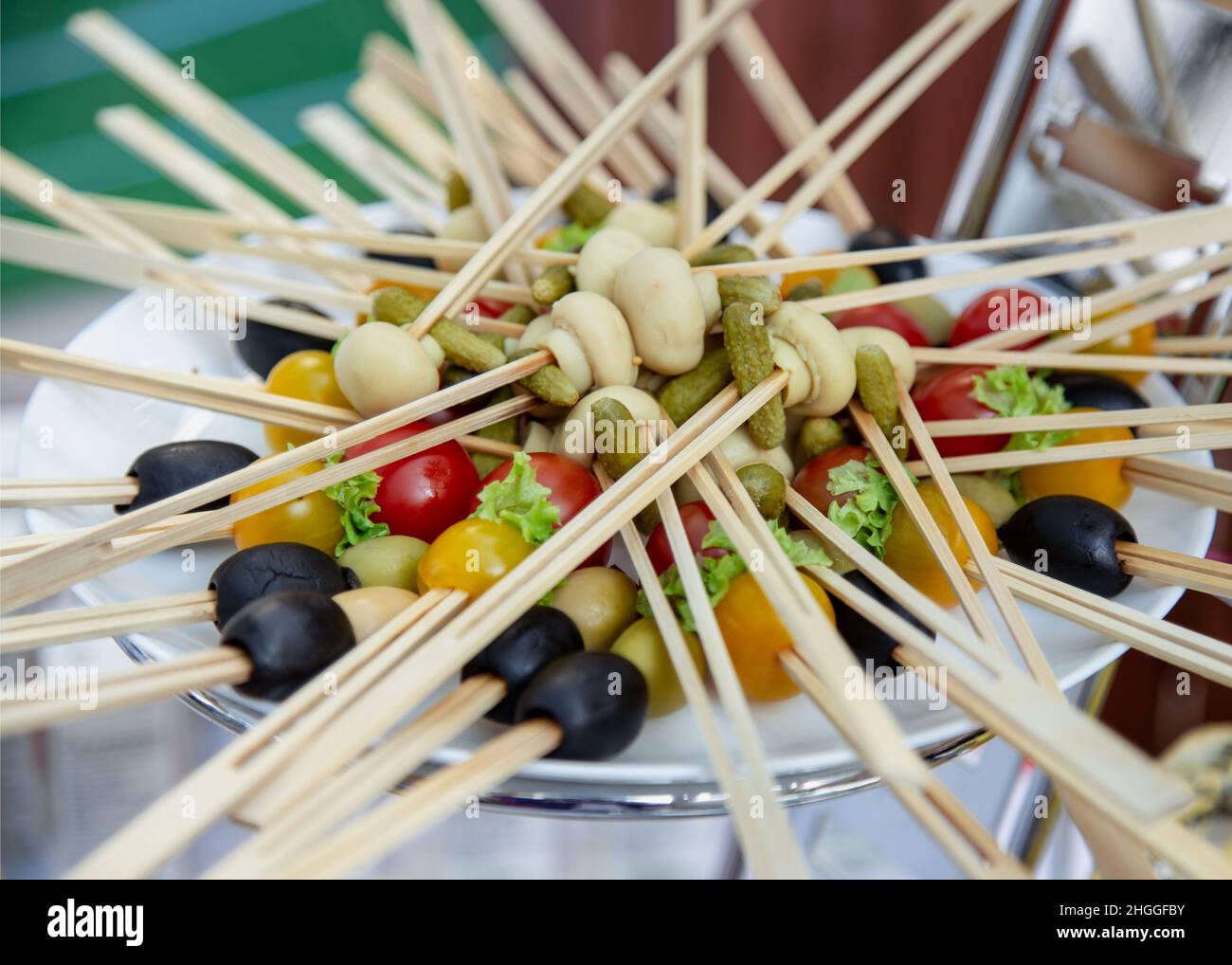 Spicy vegetable platter on wooden skewers. Green and black olive