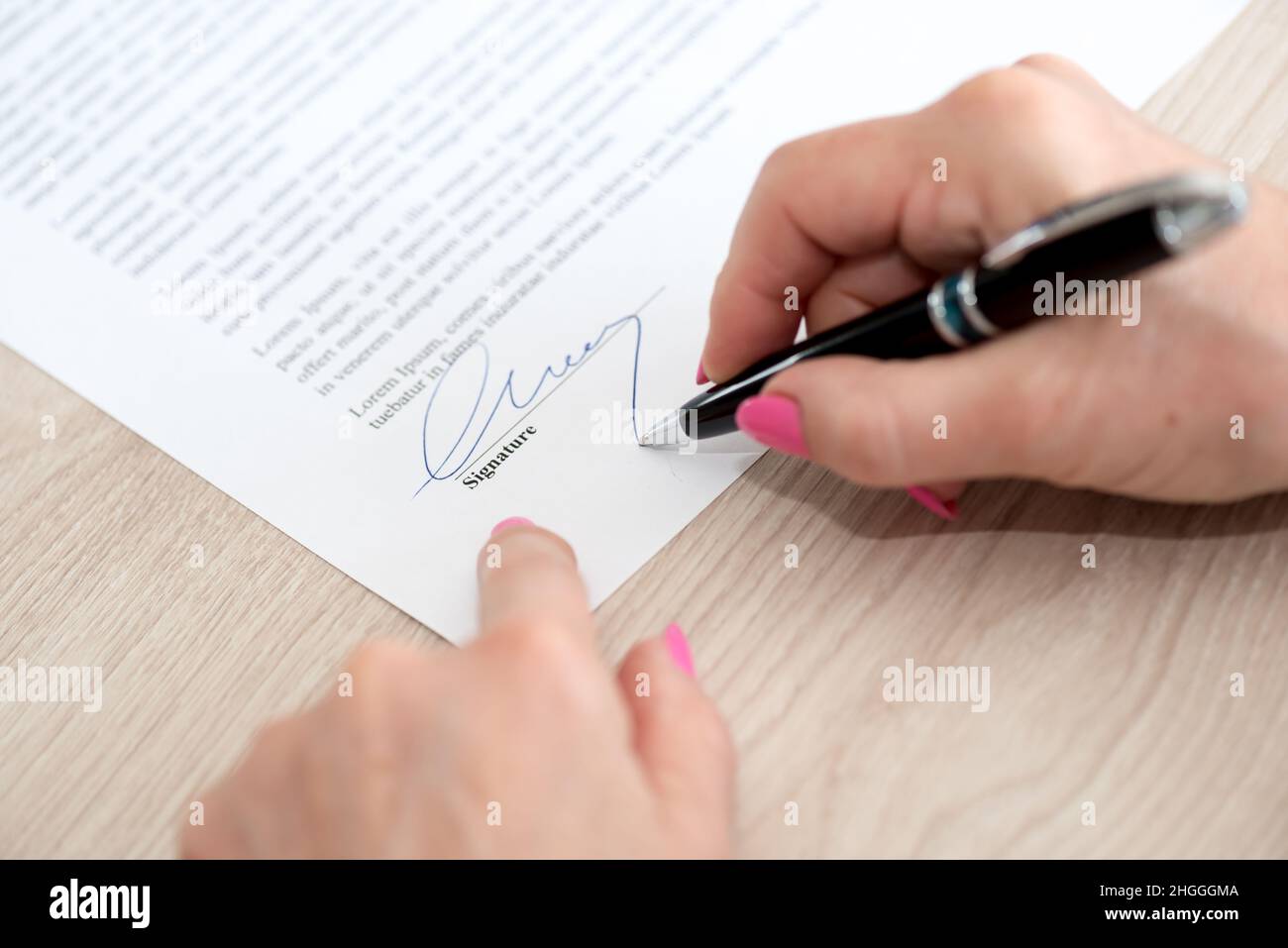 Woman signing a legal document Stock Photo - Alamy