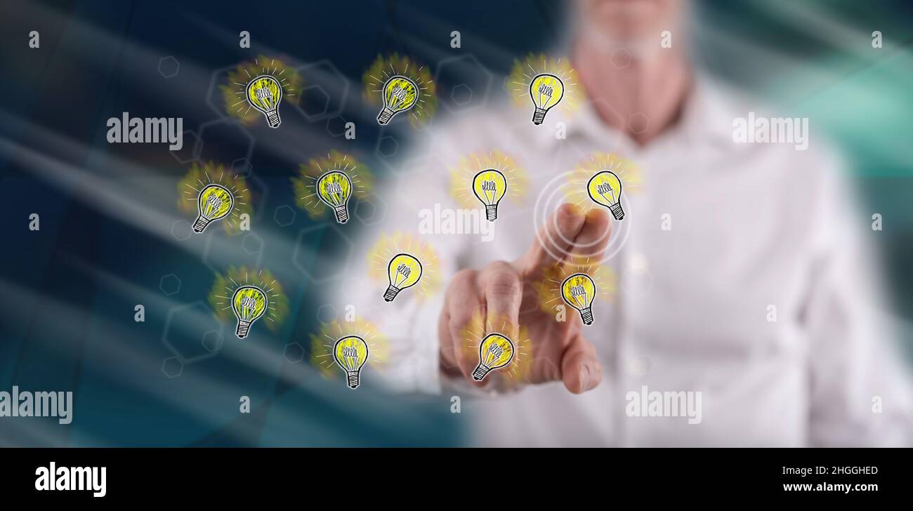 Man touching light bulbs on a touch screen with his finger Stock Photo