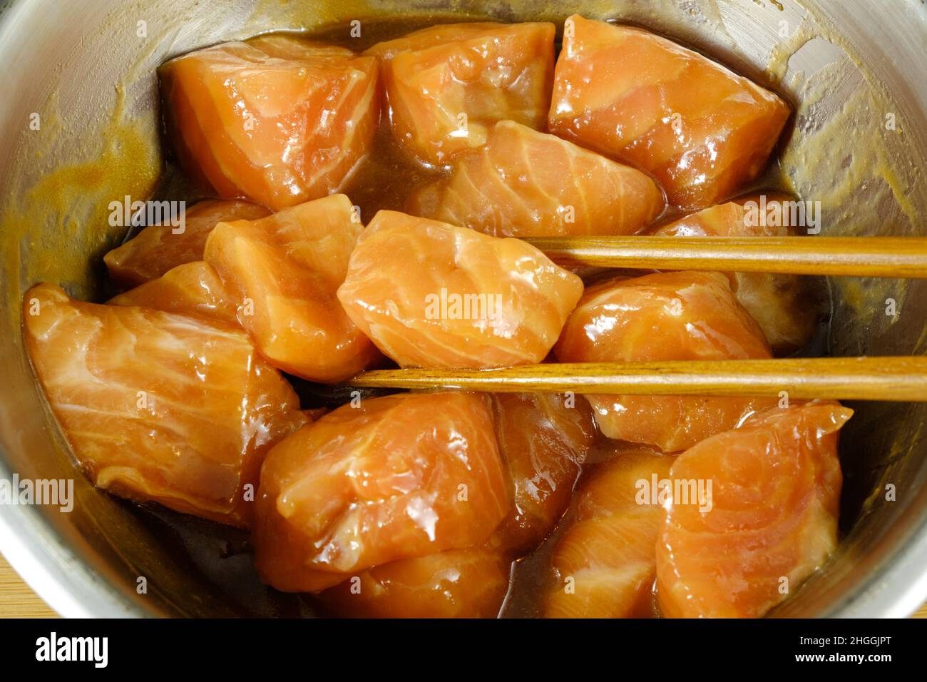 Cubes of fresh Salmon marinating in a teriyaki asian sauce Stock Photo