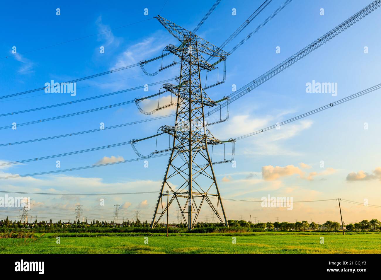 High voltage power tower industrial landscape at sunrise,urban power transmission lines. Stock Photo