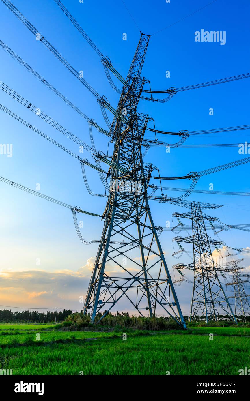 High voltage power tower industrial landscape at sunrise,urban power transmission lines. Stock Photo