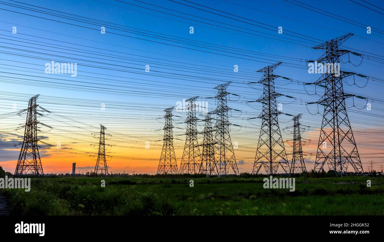 High voltage power tower industrial landscape at sunrise,urban power transmission lines. Stock Photo