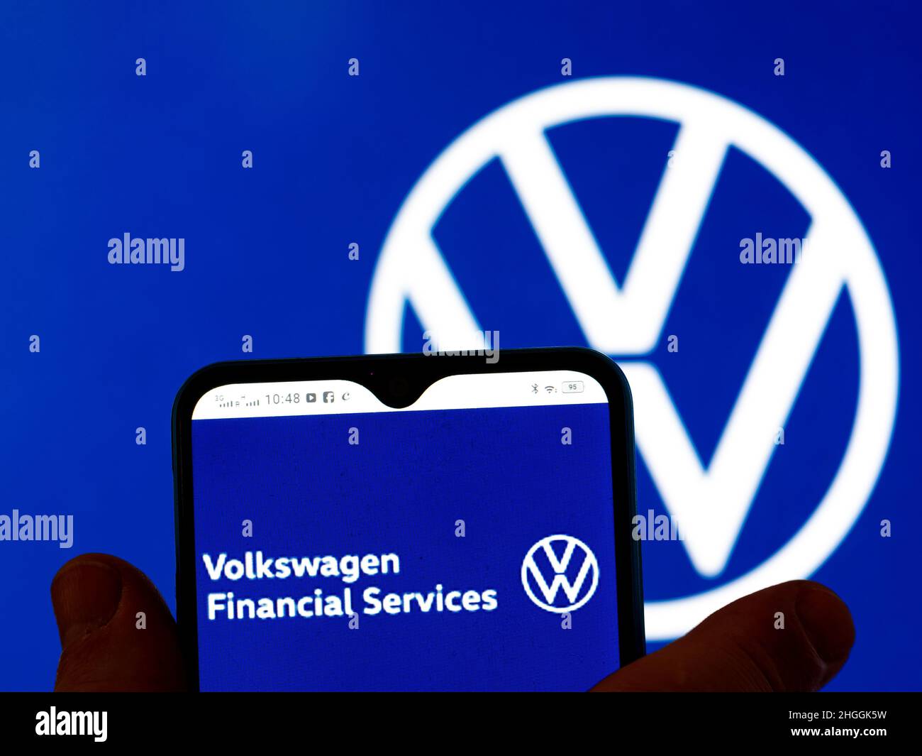 In this photo illustration, the Volkswagen Financial Services logo is seen  displayed on a smartphone screen with the Volkswagen AG logo in the  background Stock Photo - Alamy