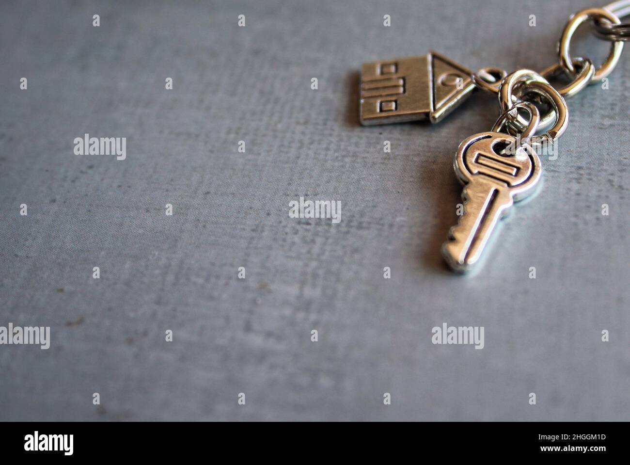 Selective focus image of house key on concrete floor with copy space for text. Home ownership concept. Stock Photo