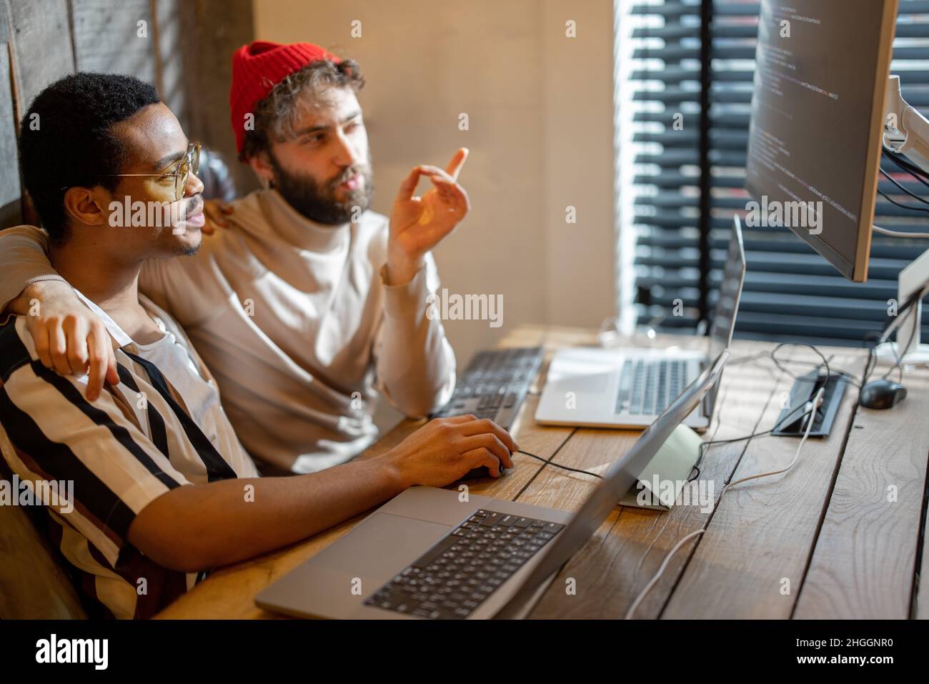 Gay couple working on computers at home office Stock Photo