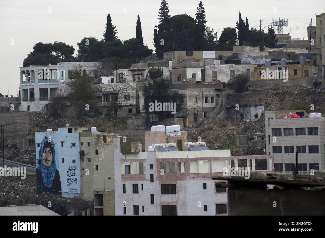 View of Amman Jordan cityscape landscape with buildings and trees on a hill in a densely populated area and a mosque in view. Stock Photo