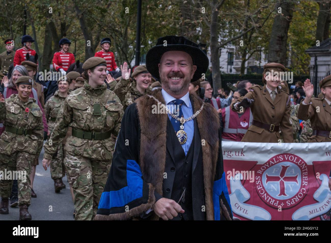 Smiling man in ceremonial robes marching with The First Aid Nursing