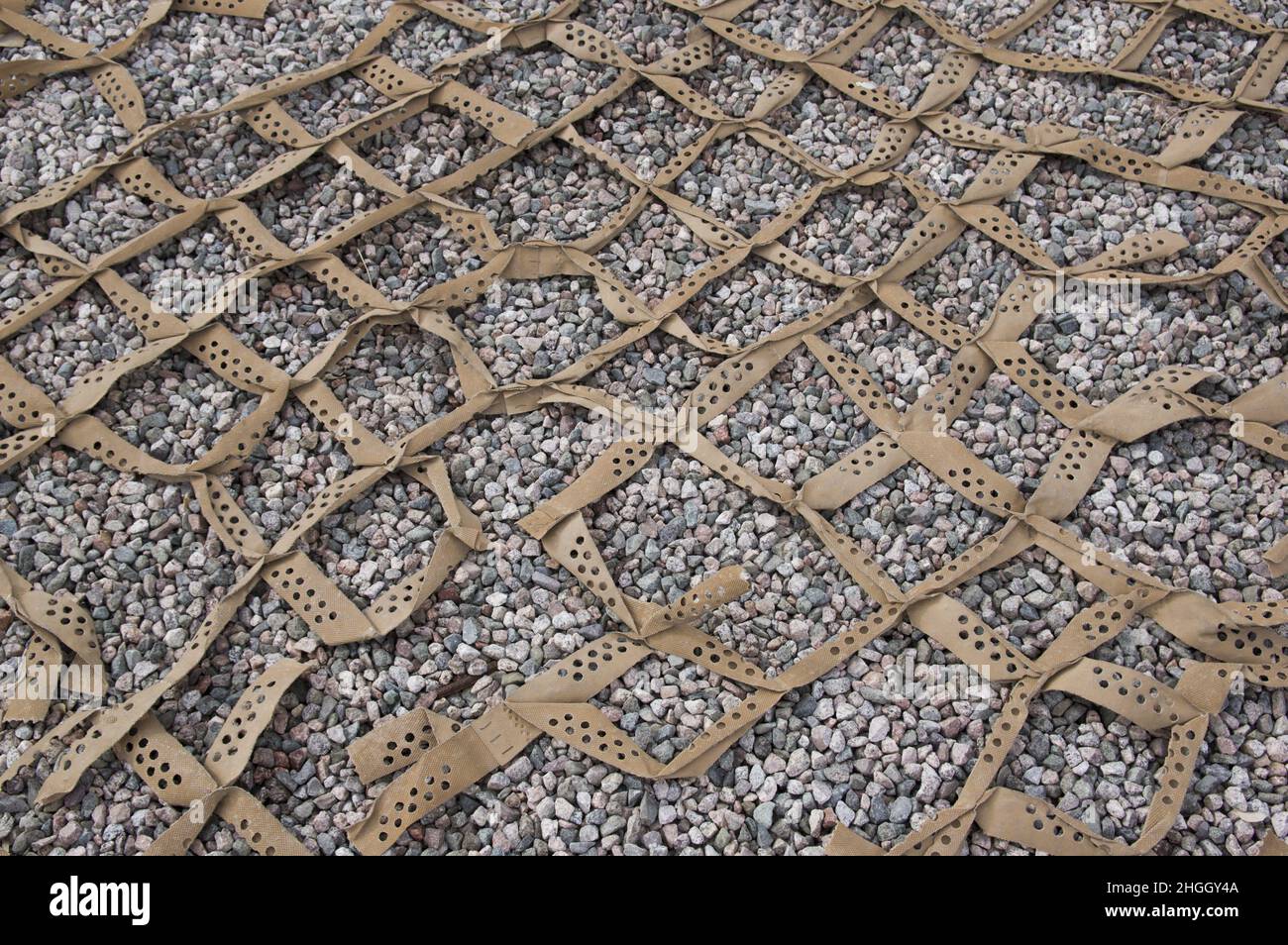 Canvas mesh laid down to prevent pebbles shifting. Construction method landscape fabric below gravel to prevent foot traffic from displacing and weeds Stock Photo
