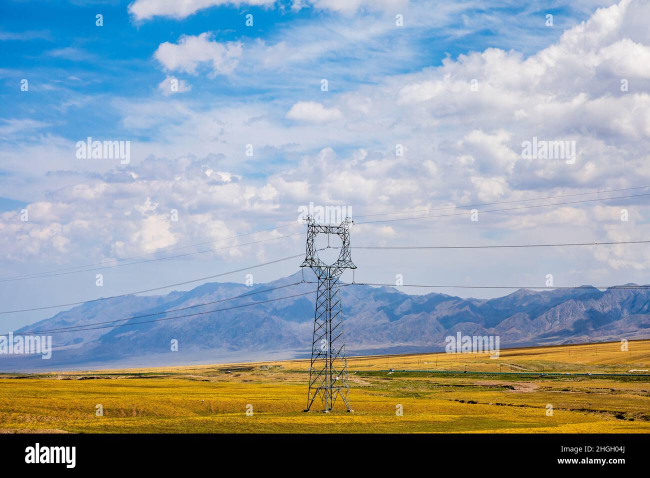 High voltage power tower and beautiful mountain scenery in Xinjiang,China. Stock Photo