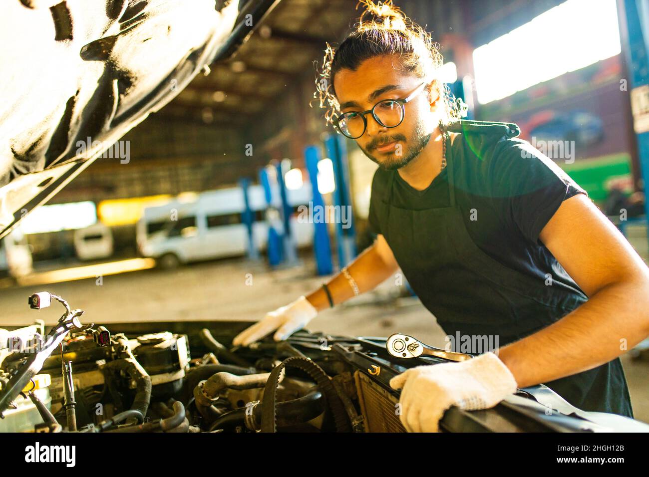 indian man auto mechanic working indoors in car shop Stock Photo