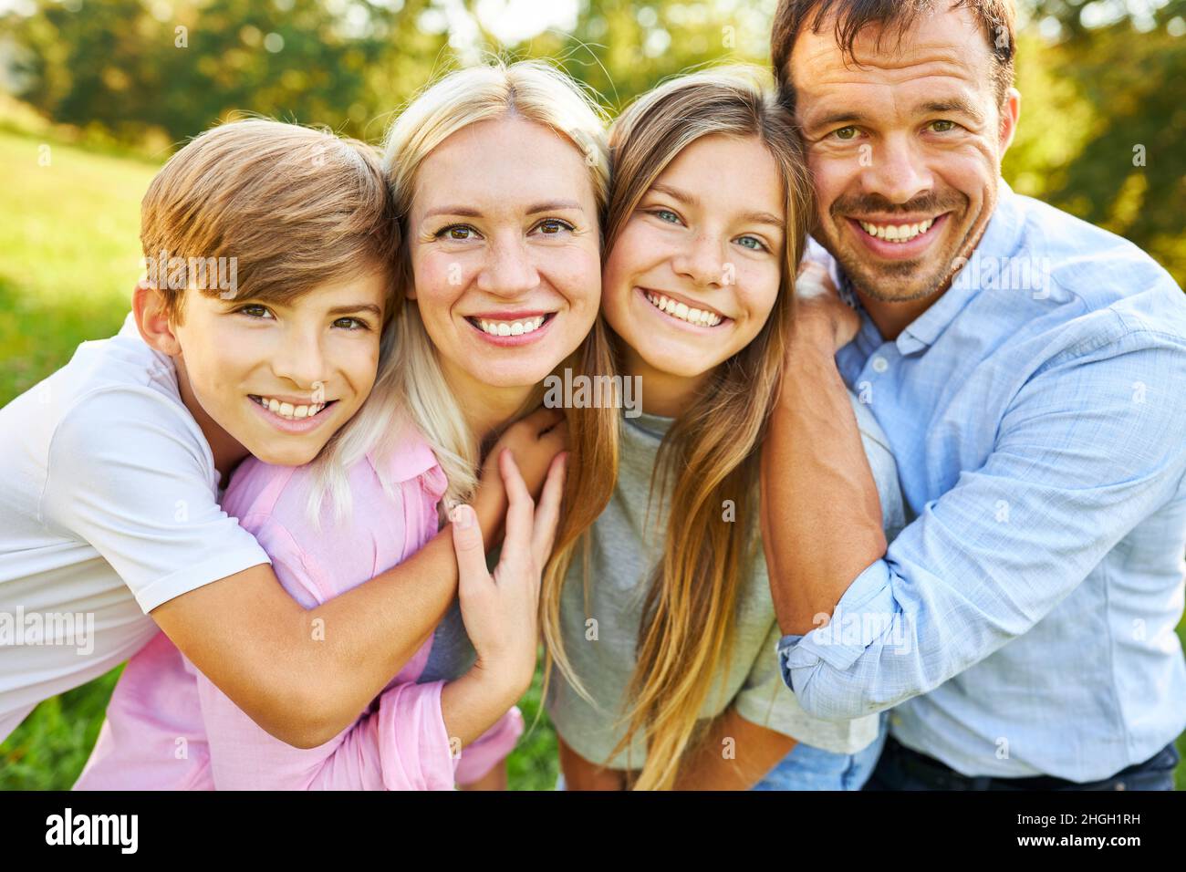 Happy family with daughter and son standing side by side in summer in nature Stock Photo