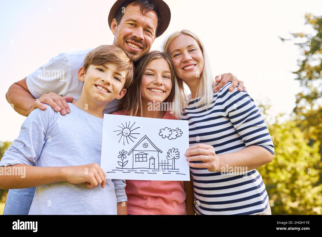 Happy family and two children with a drawing of the dream house of the