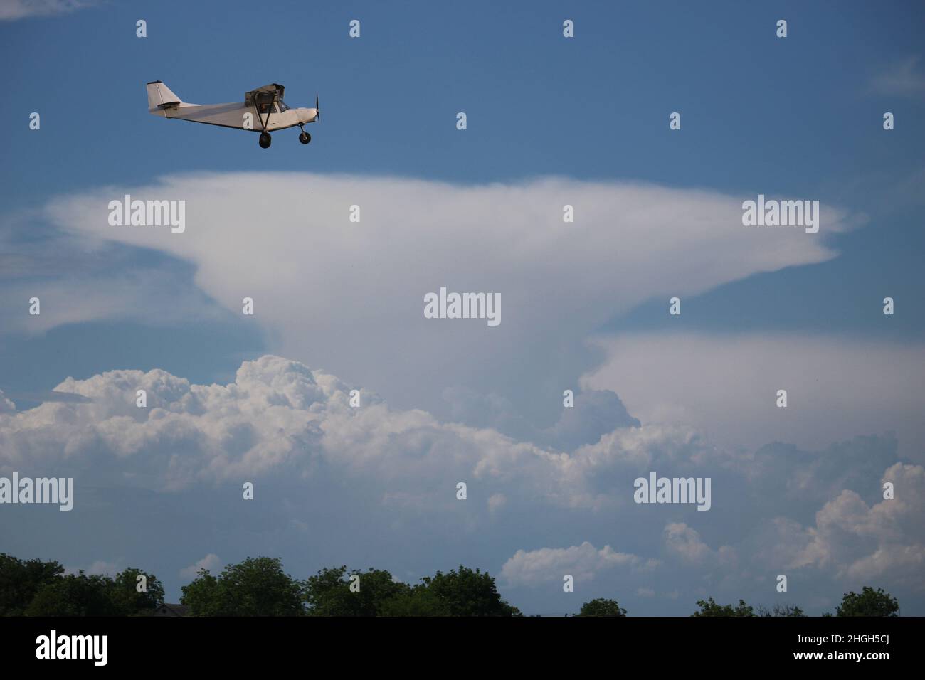 Small private single-propeller plane against the blue cloudy sky. Stock Photo