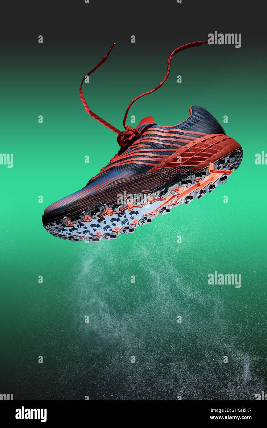 Trail running shoe, studio shot with water vapour splash on green