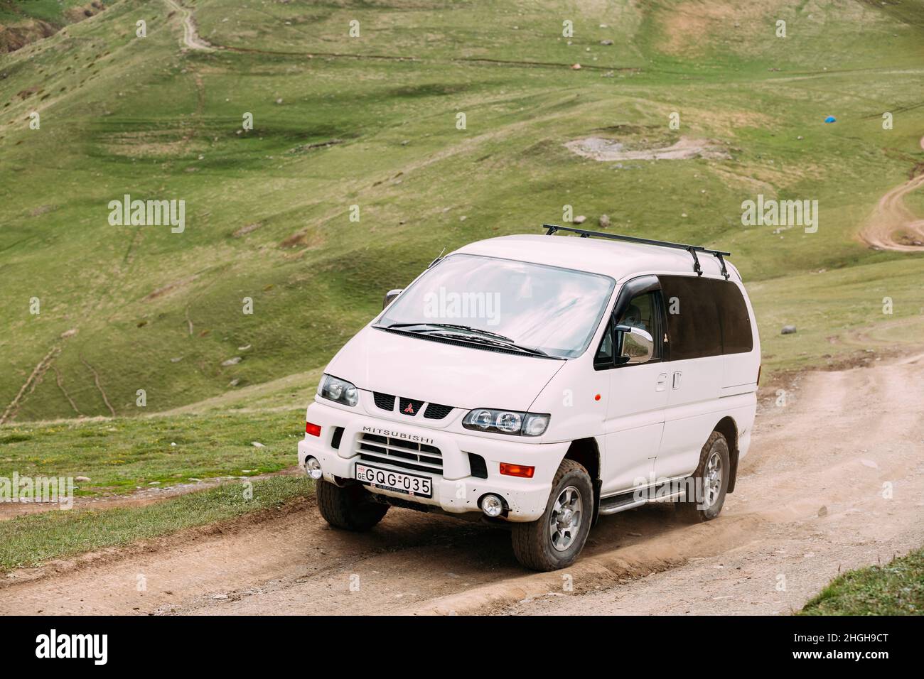 Mitsubishi Delica Space Gear on off road in Georgian summer mountains landscape. Delica is a range of trucks and multi-purpose vehicles produced by Stock Photo