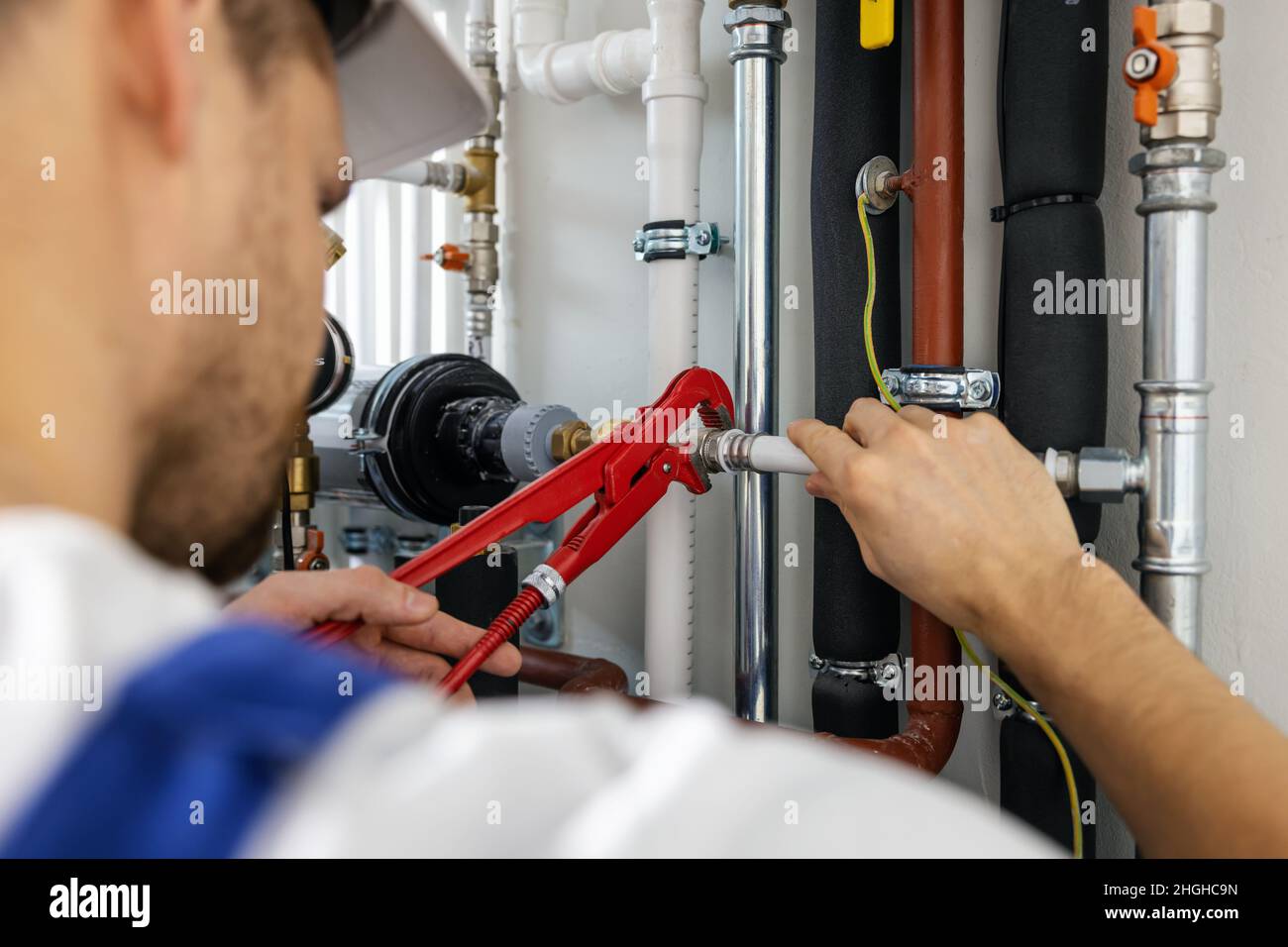 plumber working with pipelines. tighten plumbing fittings Stock Photo