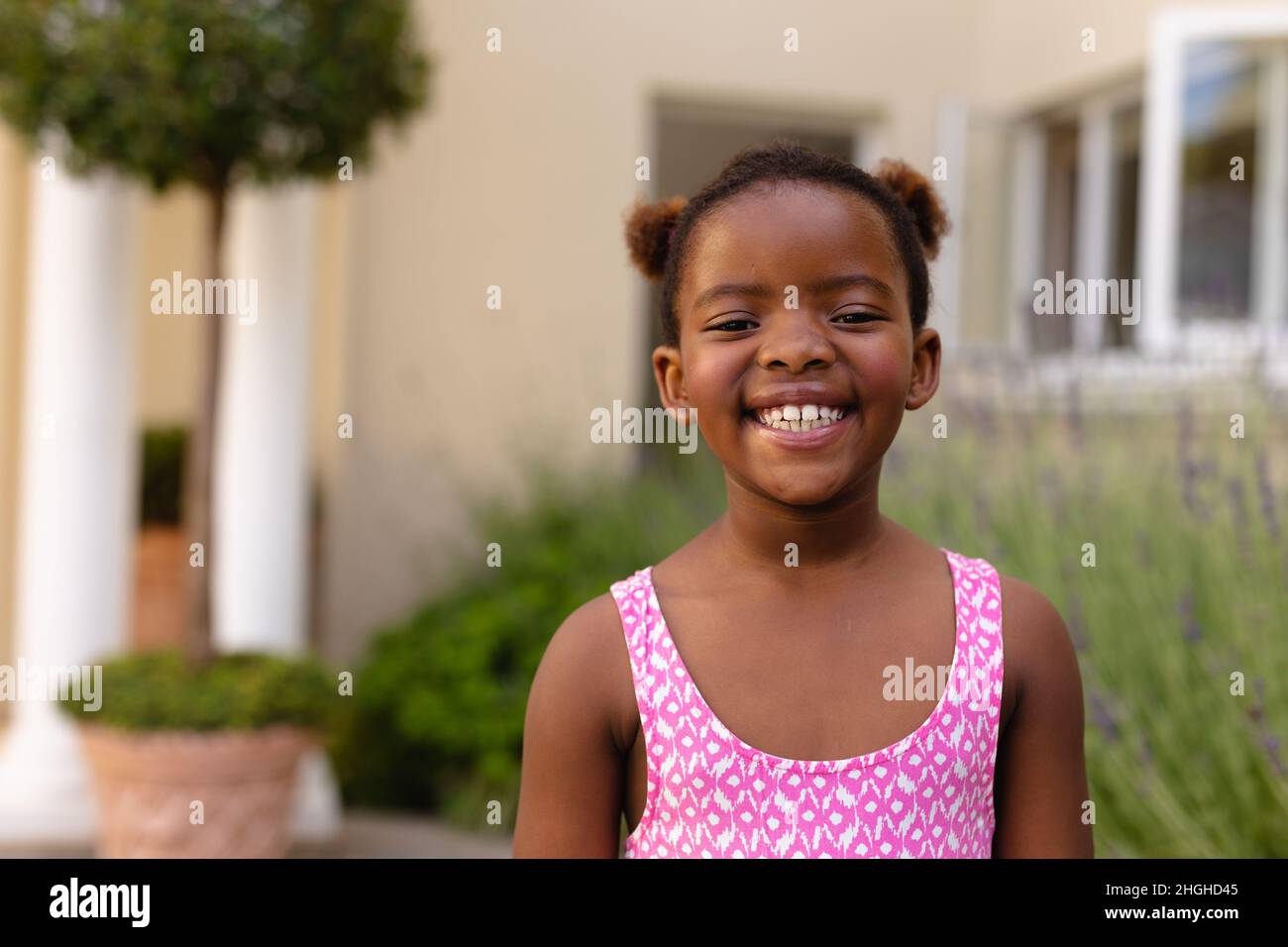 Portrait of happy cute african american girl wearing pink sleeveless top Stock Photo