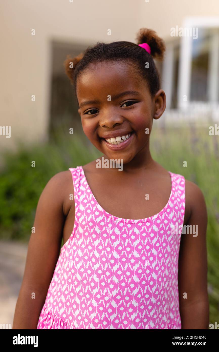 Portrait of smiling cute african american girl wearing pink sleeveless top Stock Photo
